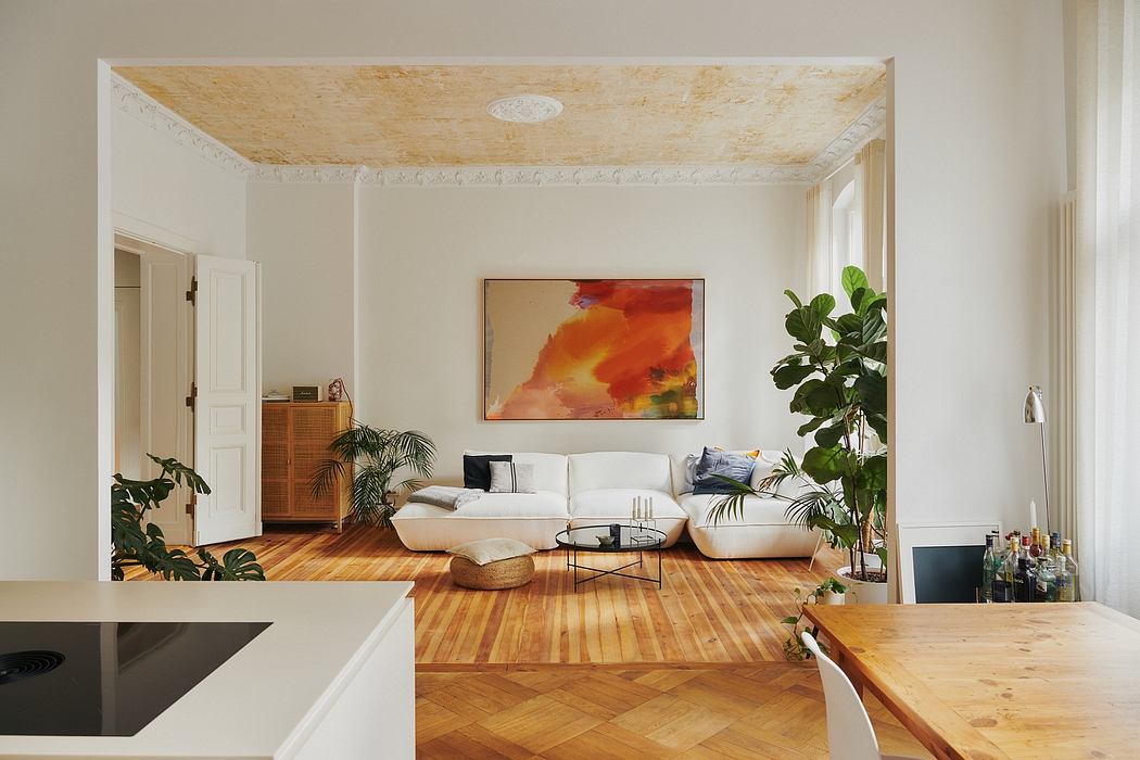 Bright, airy living space with exposed wooden ceiling, modern artwork, and lush plant life.