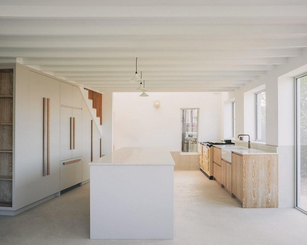 Minimalist, open-concept kitchen with clean lines, natural wood cabinetry, and large windows.