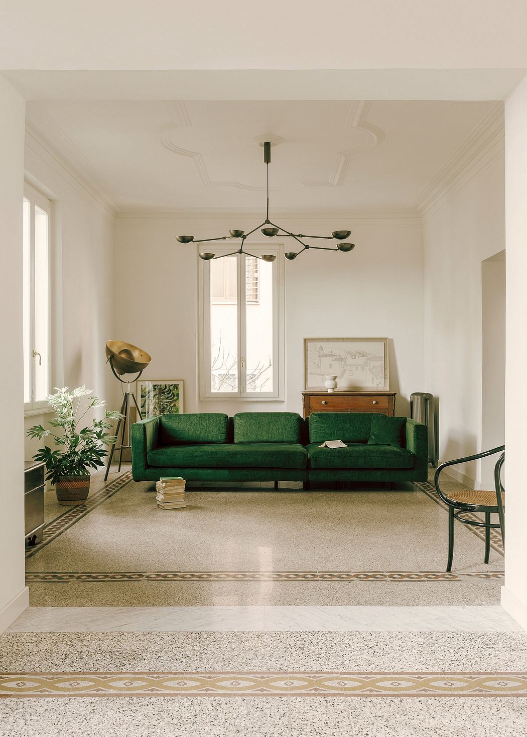 Elegant living room with a striking green sofa, vintage furniture, and decorative lighting.
