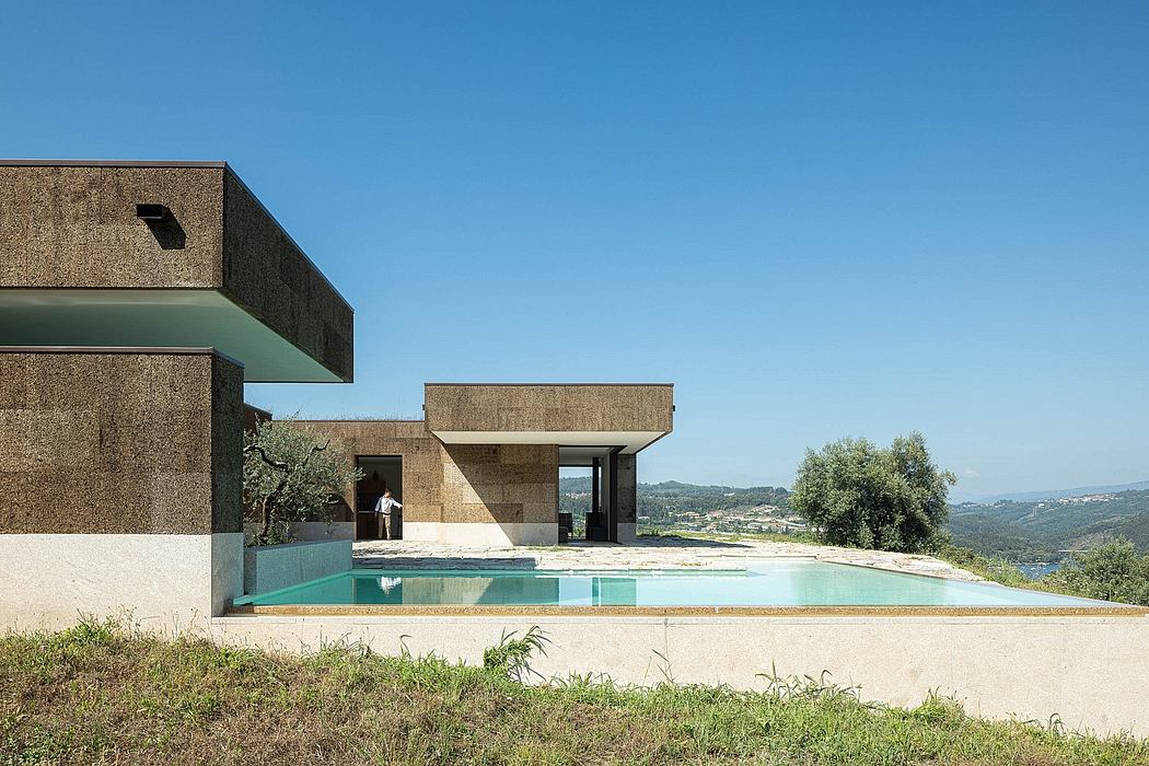 A modernist building with geometric shapes, a swimming pool, and sweeping views of the landscape.