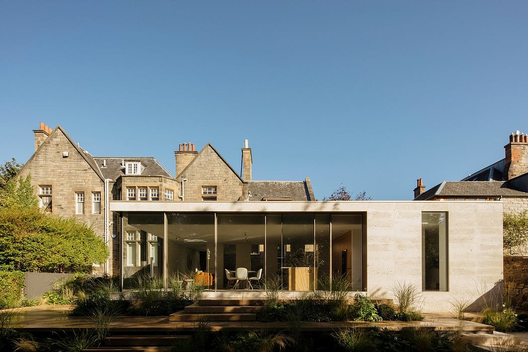 A modern glass extension contrasts with the historic masonry building, creating a harmonious blend.