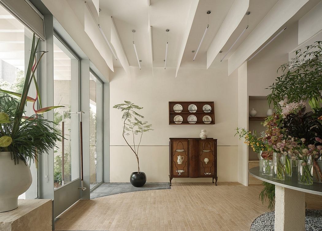 Expansive space with high ceilings, floor-to-ceiling windows, and a mix of modern and vintage furnishings.