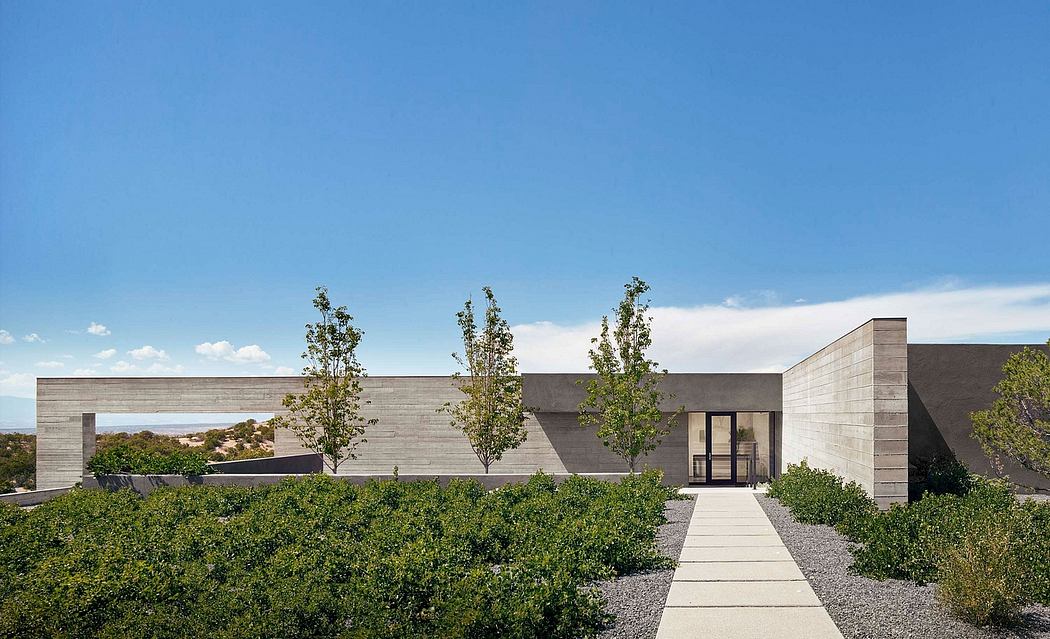 A modern concrete building with a clean, minimalist design and a landscaped walkway.