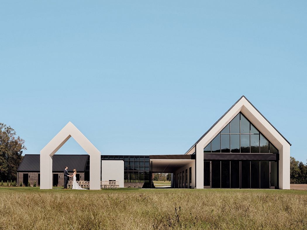 A modern, minimalist building with large windows and a distinctive gabled roof design.