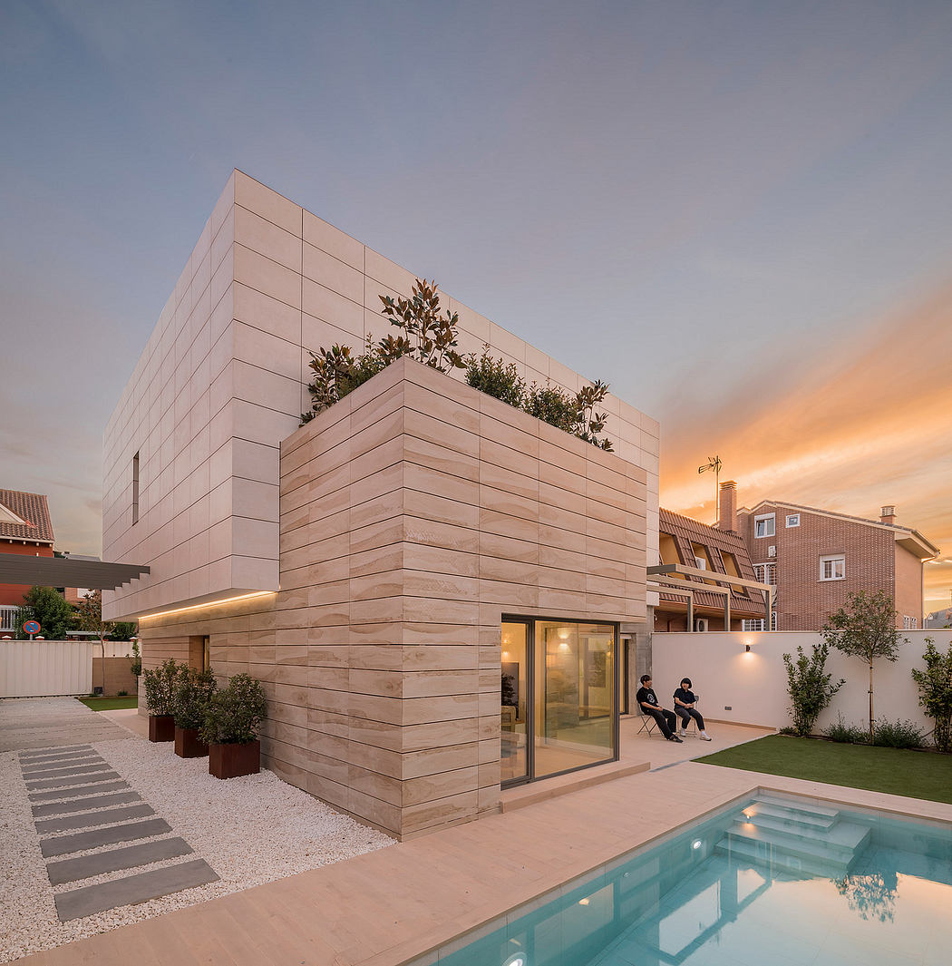 A modern, minimalist building with a striking geometric design and a pool in the foreground.