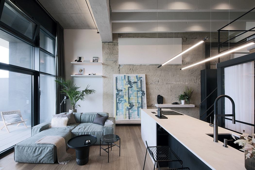 Contemporary open-plan living area with exposed concrete walls, built-in shelves, and stylish furnishings.