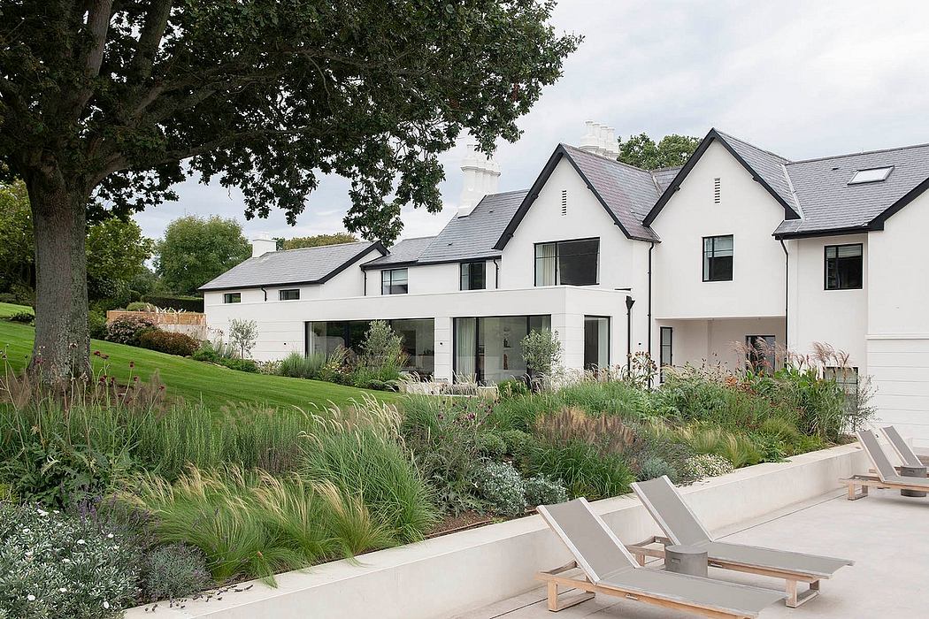 A modern farmhouse-style home with a well-landscaped garden and seating area.