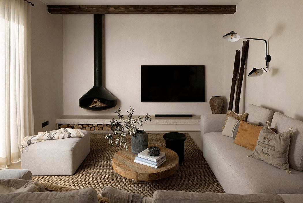 Cozy living room with wood beams, stone fireplace, and earthy neutral tones.