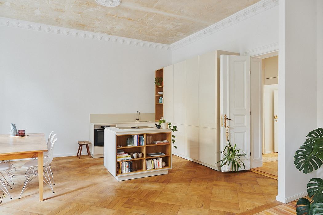 Spacious, airy kitchen with built-in shelving, wooden floors, and classic architectural details.