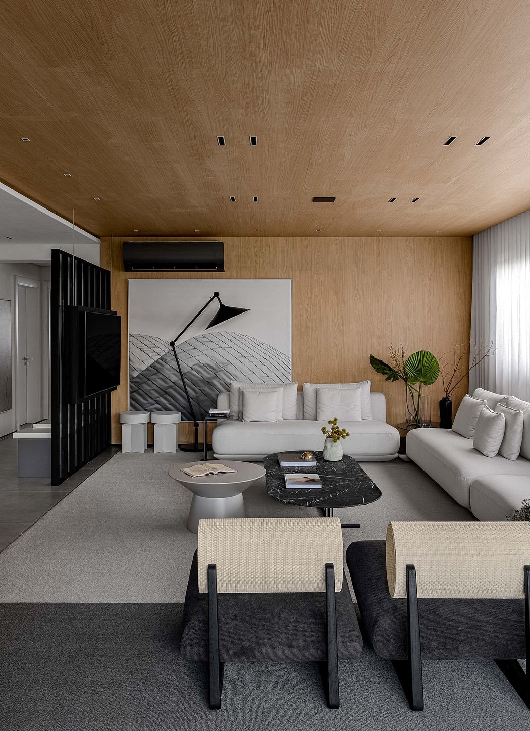 A contemporary living room with a minimalist design, featuring a white sofa, a black marble coffee table, and a large abstract artwork on the wall.