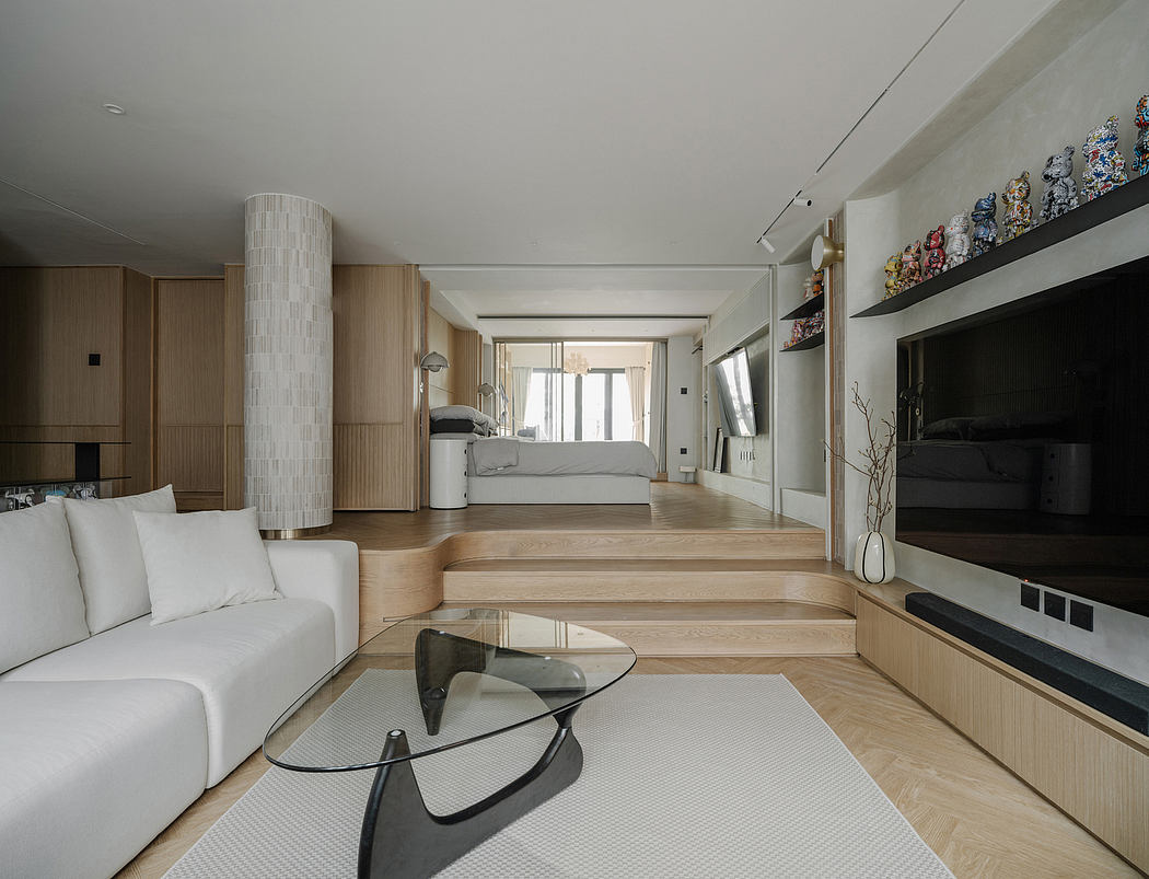 Spacious, open-concept living area with wood floors, built-in cabinetry, and glass coffee table.