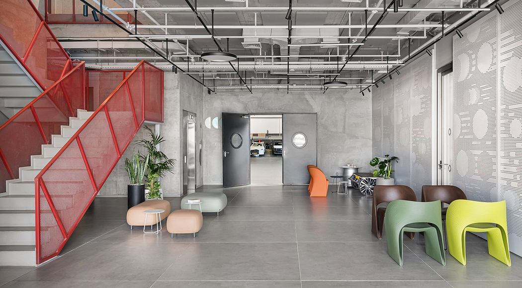 Vibrant industrial-style interior with bold red staircase, concrete floors, and modern furniture.