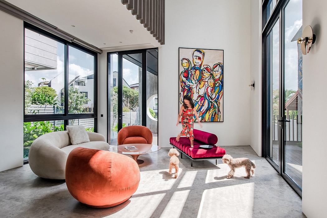 Spacious, modern living room with colorful artwork, plush seating, and large windows.