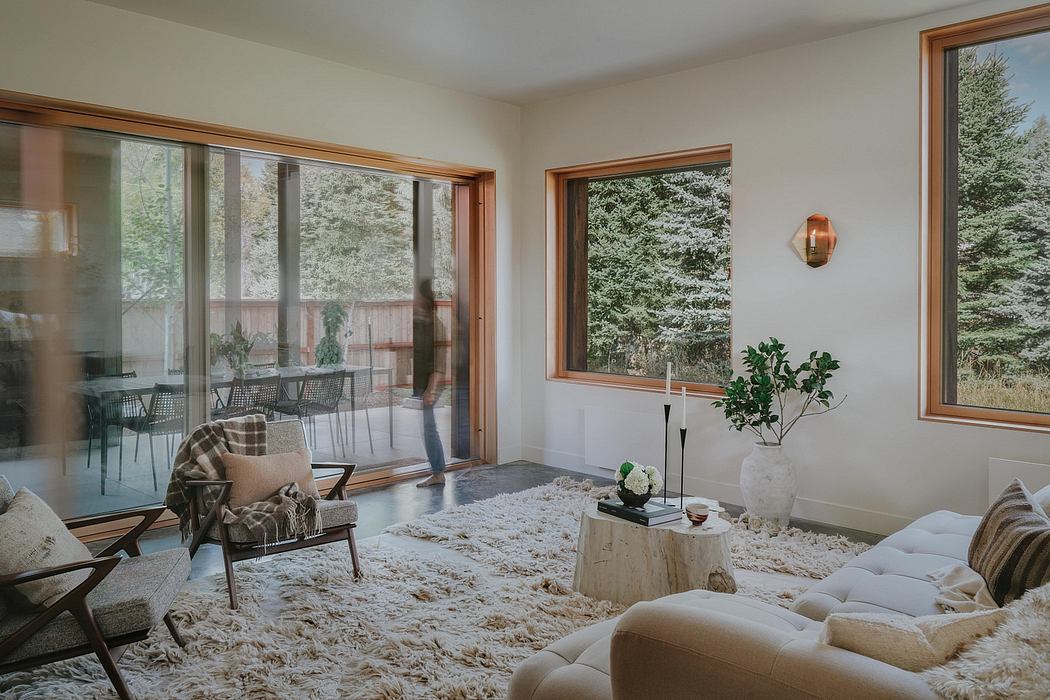 Cozy living room with large windows, wooden frames, and plush furnishings.