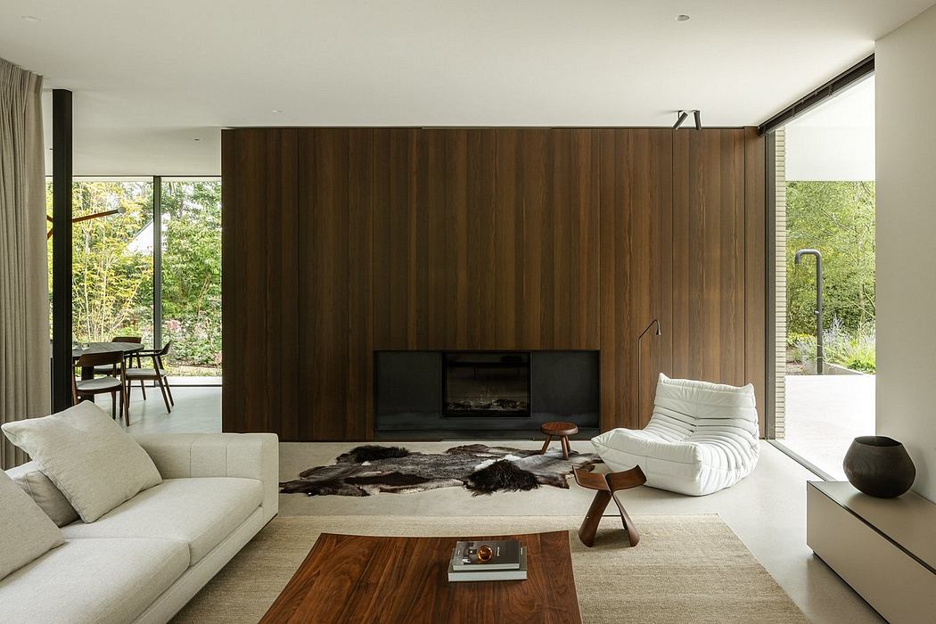 A modern living room with wooden accent walls, minimalist furniture, and floor-to-ceiling windows overlooking nature.