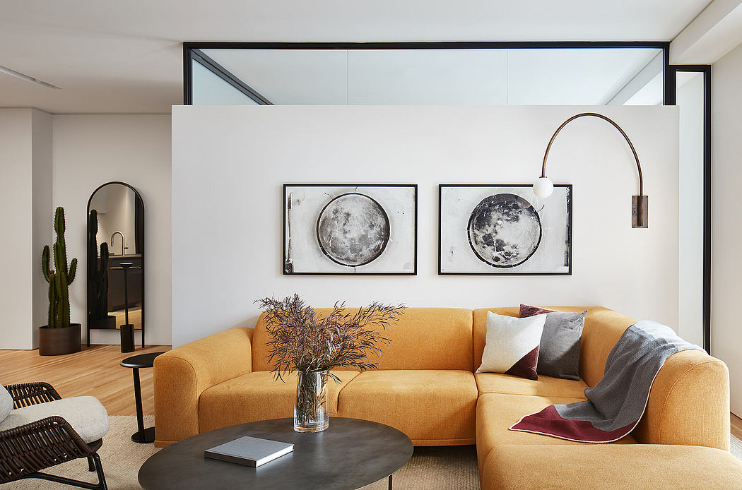 Modern living room with sleek design, floor-to-ceiling windows, and framed moon phase artwork.