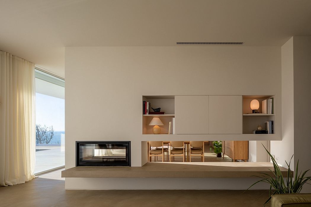 Minimalist living room with built-in shelves, fireplace, and large window providing natural light.