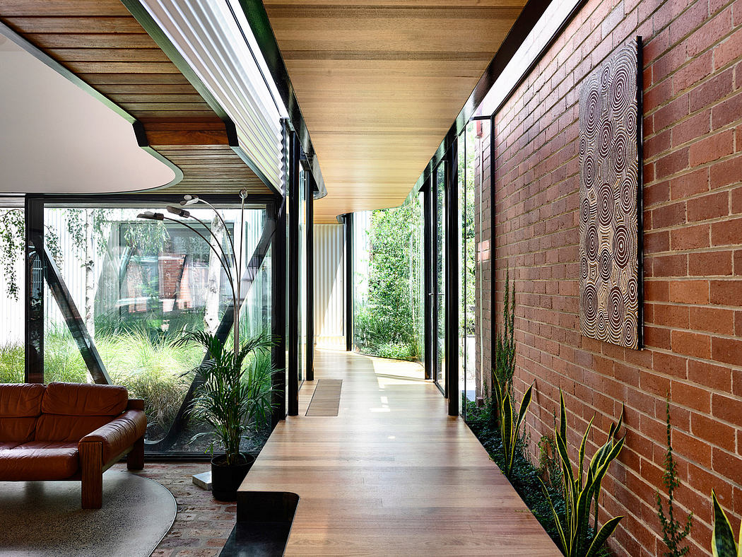Spacious interior with wooden ceiling, brick walls, and glass doors overlooking a garden.