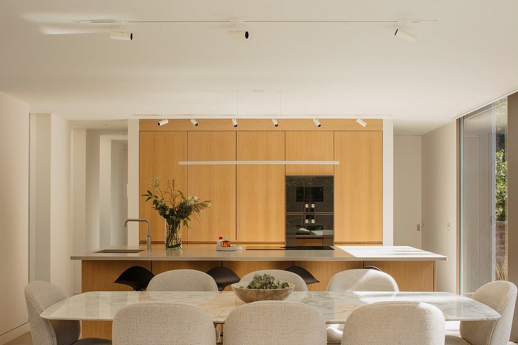 Spacious, modern kitchen with sleek wooden cabinetry, ample countertop, and track lighting.