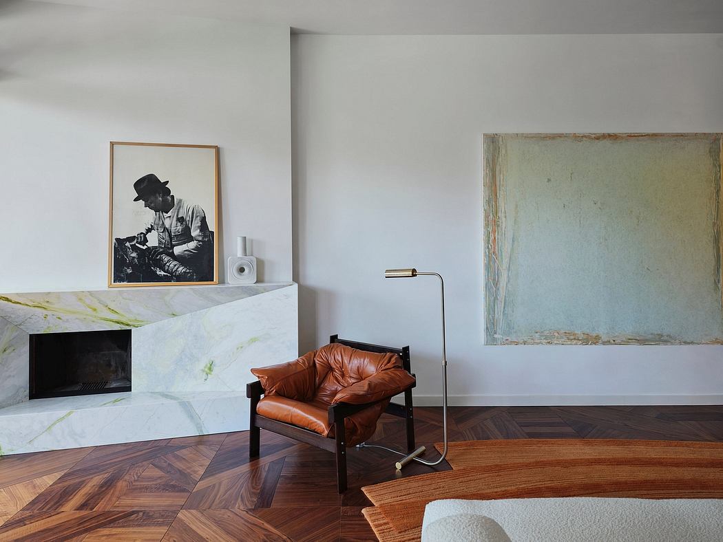 A modern living room with an industrial fireplace, a vintage leather chair, and abstract art.