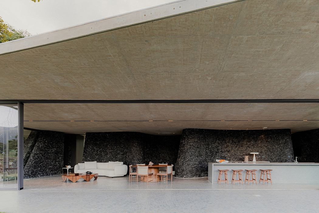 Spacious modern interior with concrete walls, minimalist furniture, and an open layout.