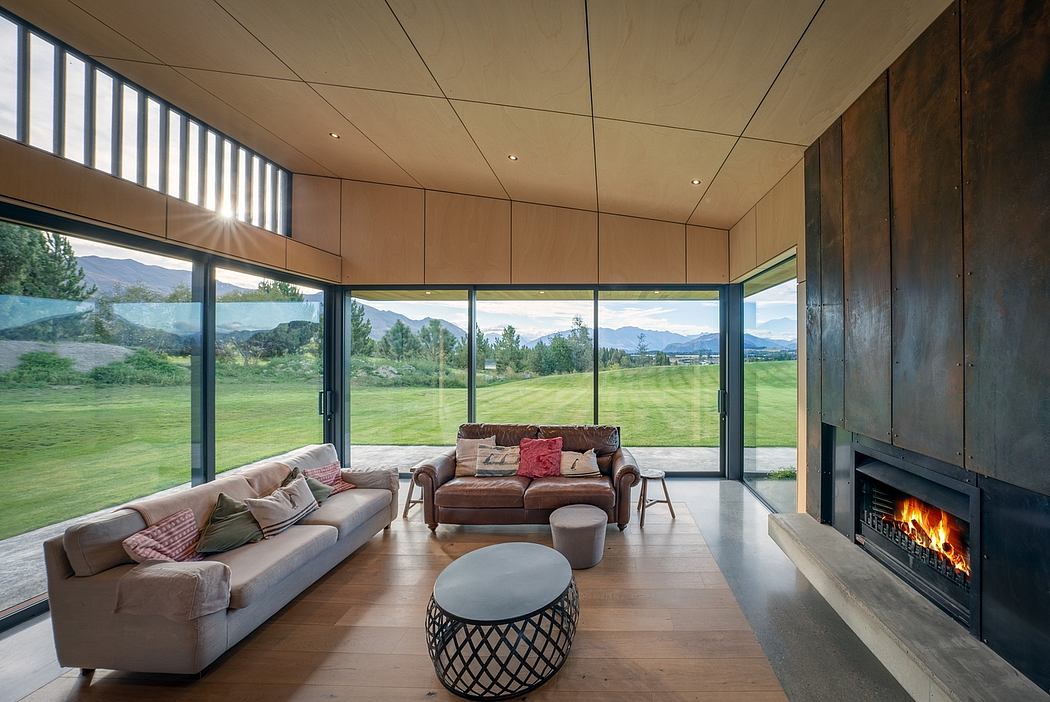 Spacious modern living room with wooden walls, large windows, and a fireplace.