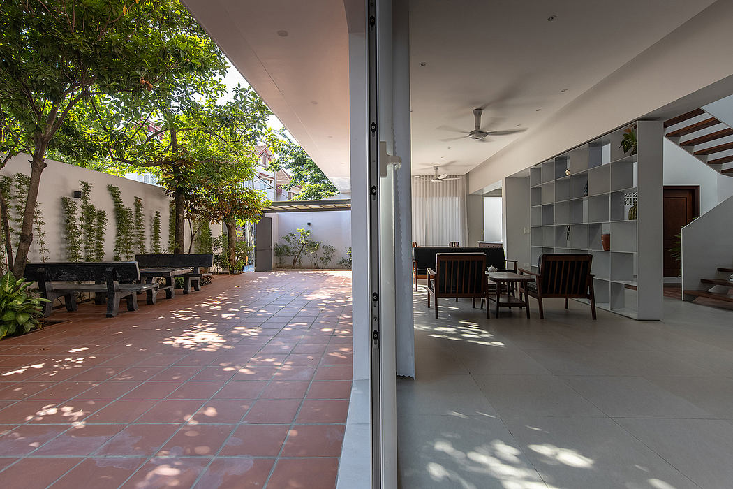 An inviting courtyard with lush greenery and modern furniture, blending indoor and outdoor living.