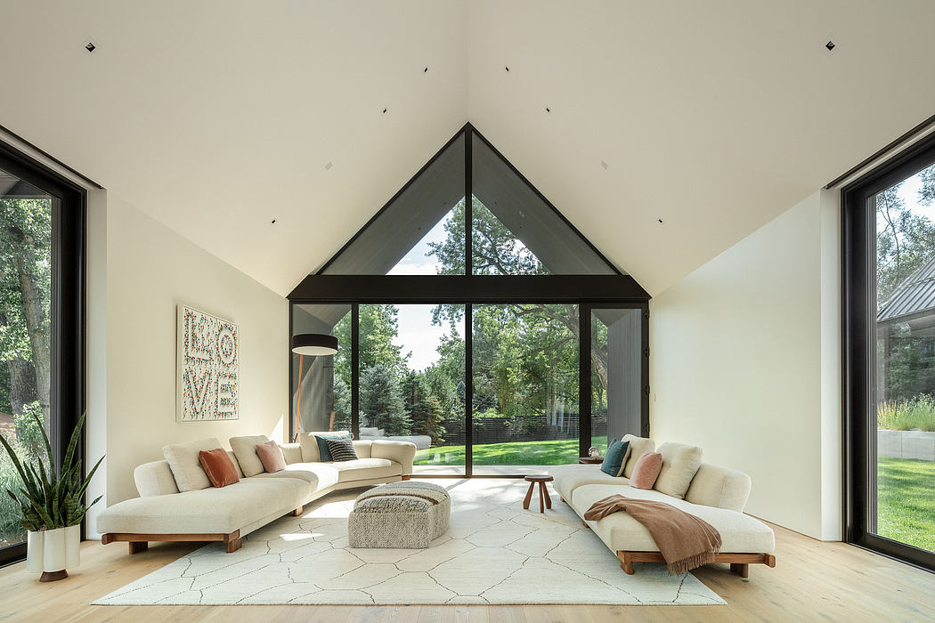 A modern, open-concept living room with triangular windows, plush seating, and a natural rug.