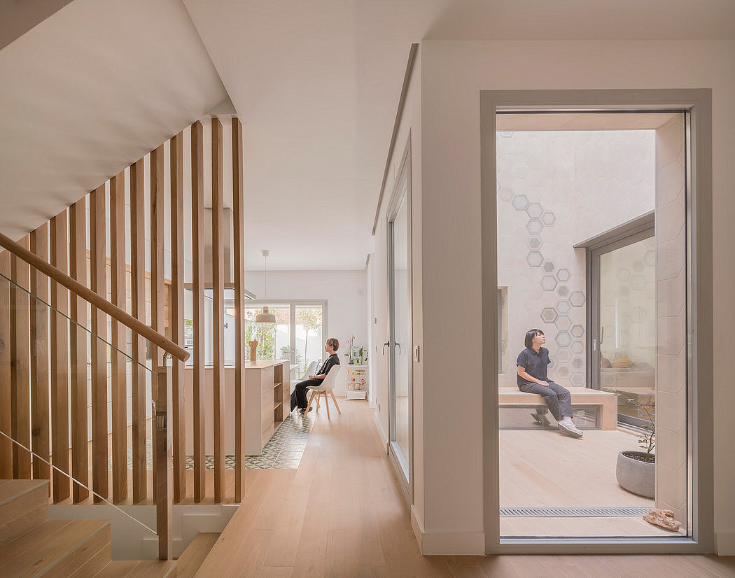 Bright, open-concept home with wooden staircase, polished floors, and large windows.