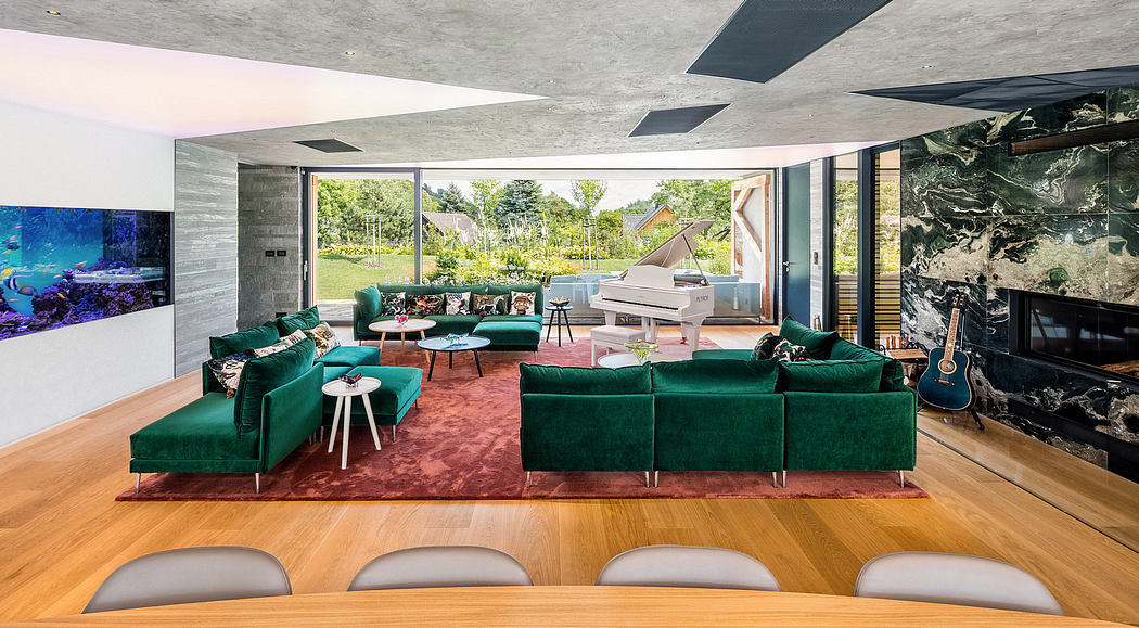 Spacious modern living room with concrete ceilings, green velvet sofas, and grand views.