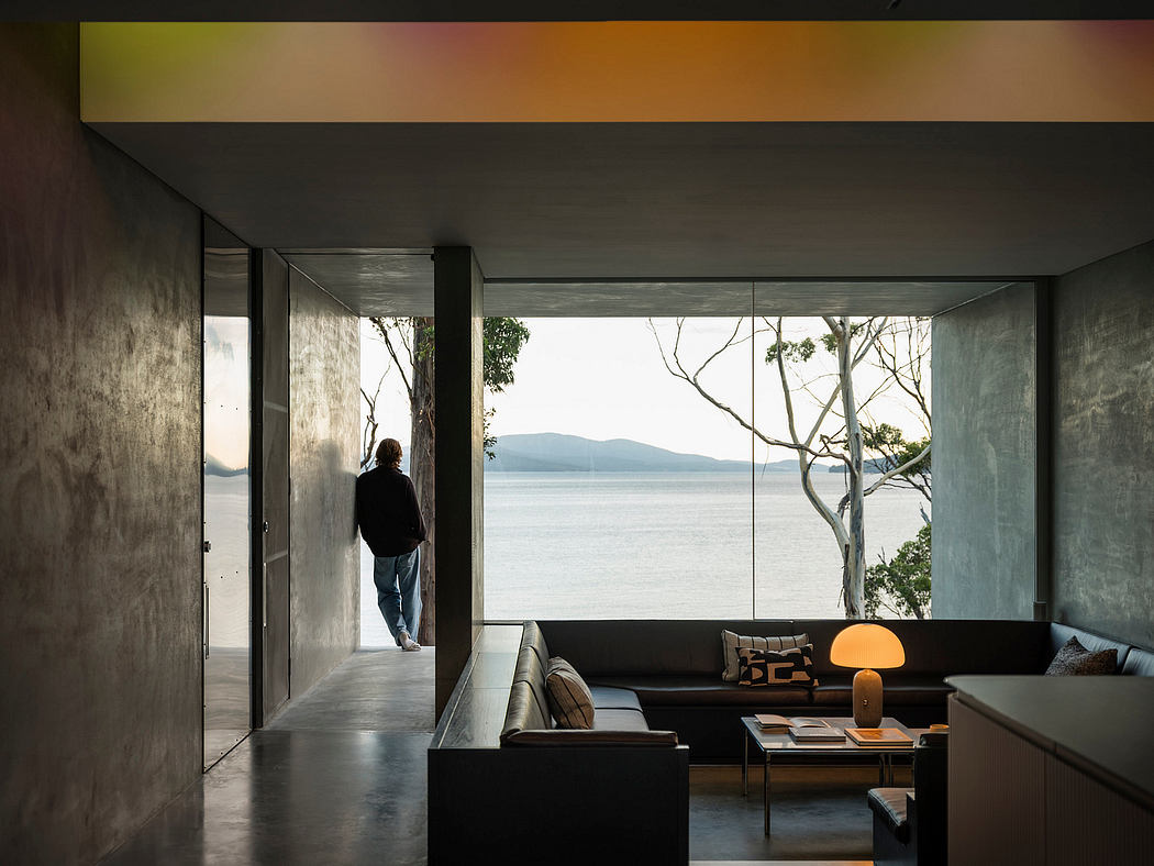 Minimalist living room with floor-to-ceiling windows offering breathtaking lake views.