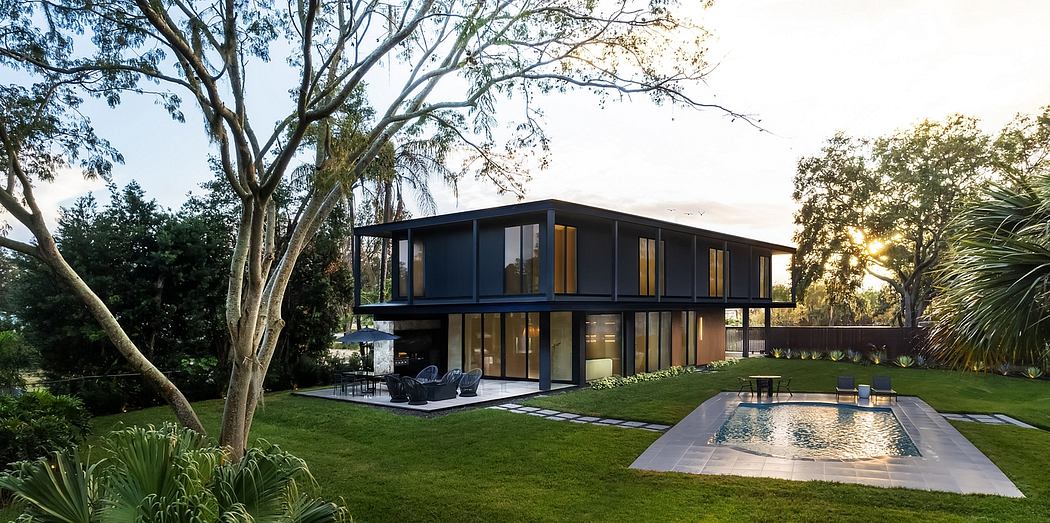 Sleek, modern house with floor-to-ceiling windows, pool, and lush landscaping.