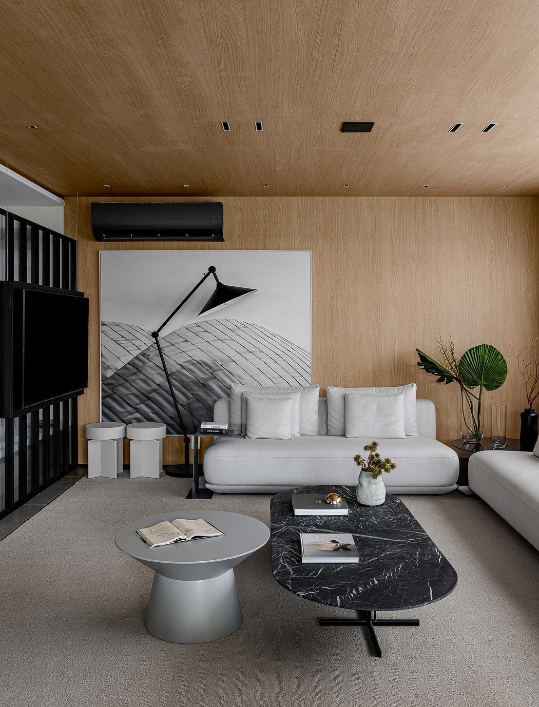 Modern minimalist living room with wood-paneled walls, white sofa, and black marble coffee table.