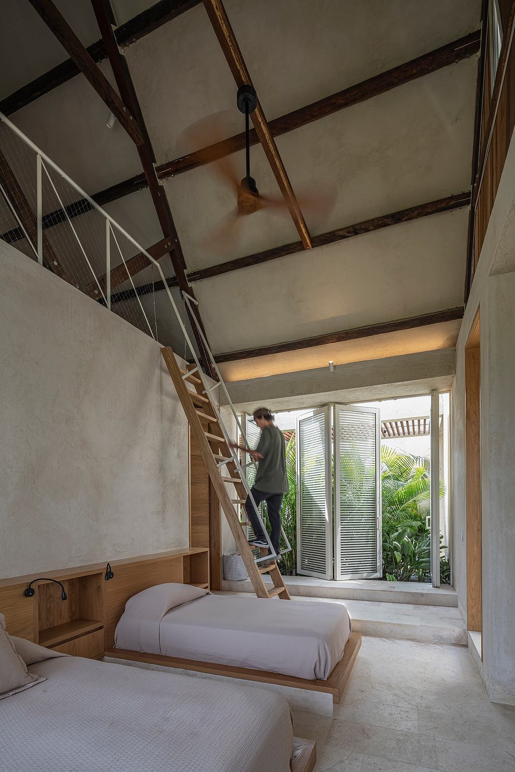 Rustic, minimalist interior with exposed wooden beams, concrete walls, and large windows overlooking greenery.