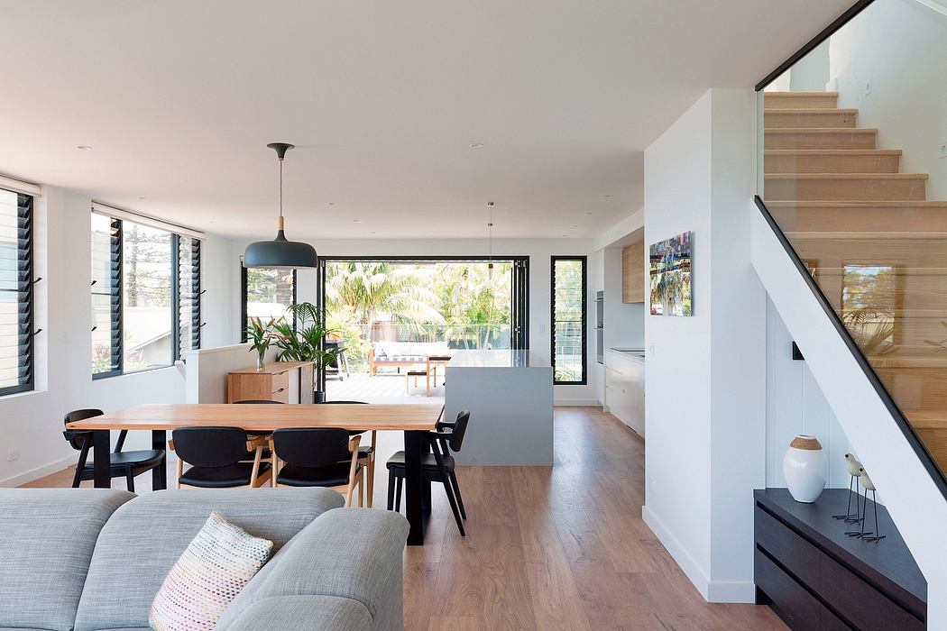 Bright, open-concept living space with wood floors, dining table, and sleek furniture.