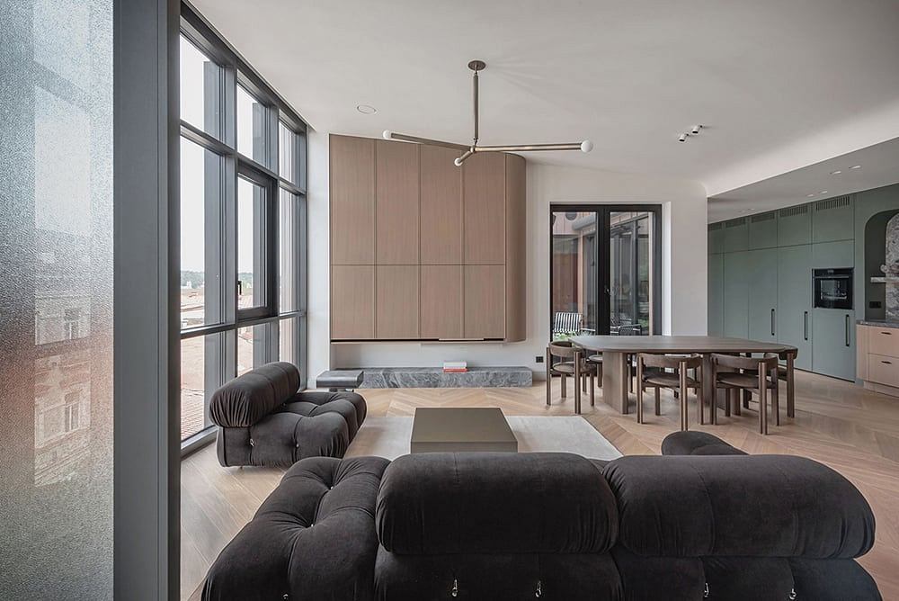 Minimalist open-plan living room with floor-to-ceiling windows, modern furniture, and a dining area.