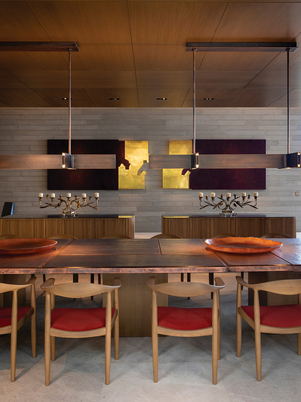 Warm, modern dining space with wood tones, textured walls, and dramatic lighting.