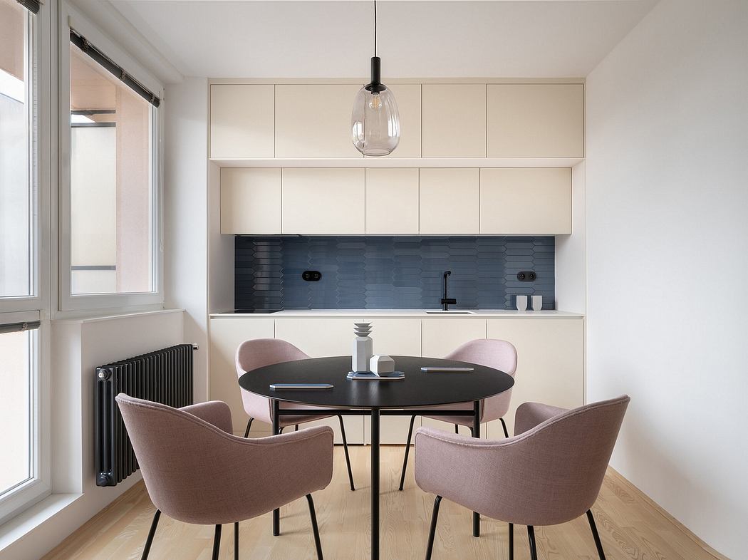 Contemporary kitchen-dining area with sleek cabinetry, backsplash, and pendant lighting.