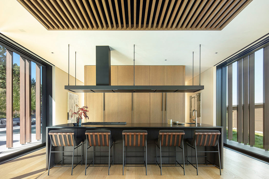 Sleek modern kitchen with wood paneled ceiling, black cabinetry, and large windows.