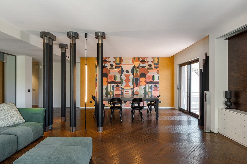 A modern, open-concept living space with bold geometric artwork, wood floors, and minimalist furnishings.