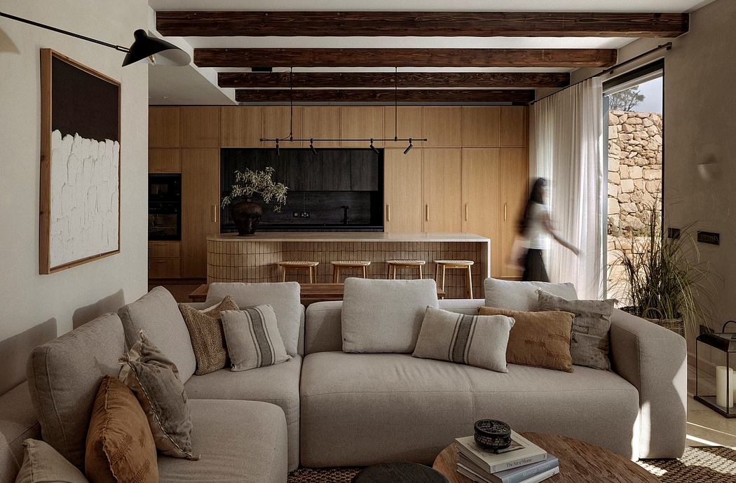 Warm, rustic living space with wooden beams, neutral tones, and a cozy seating area.