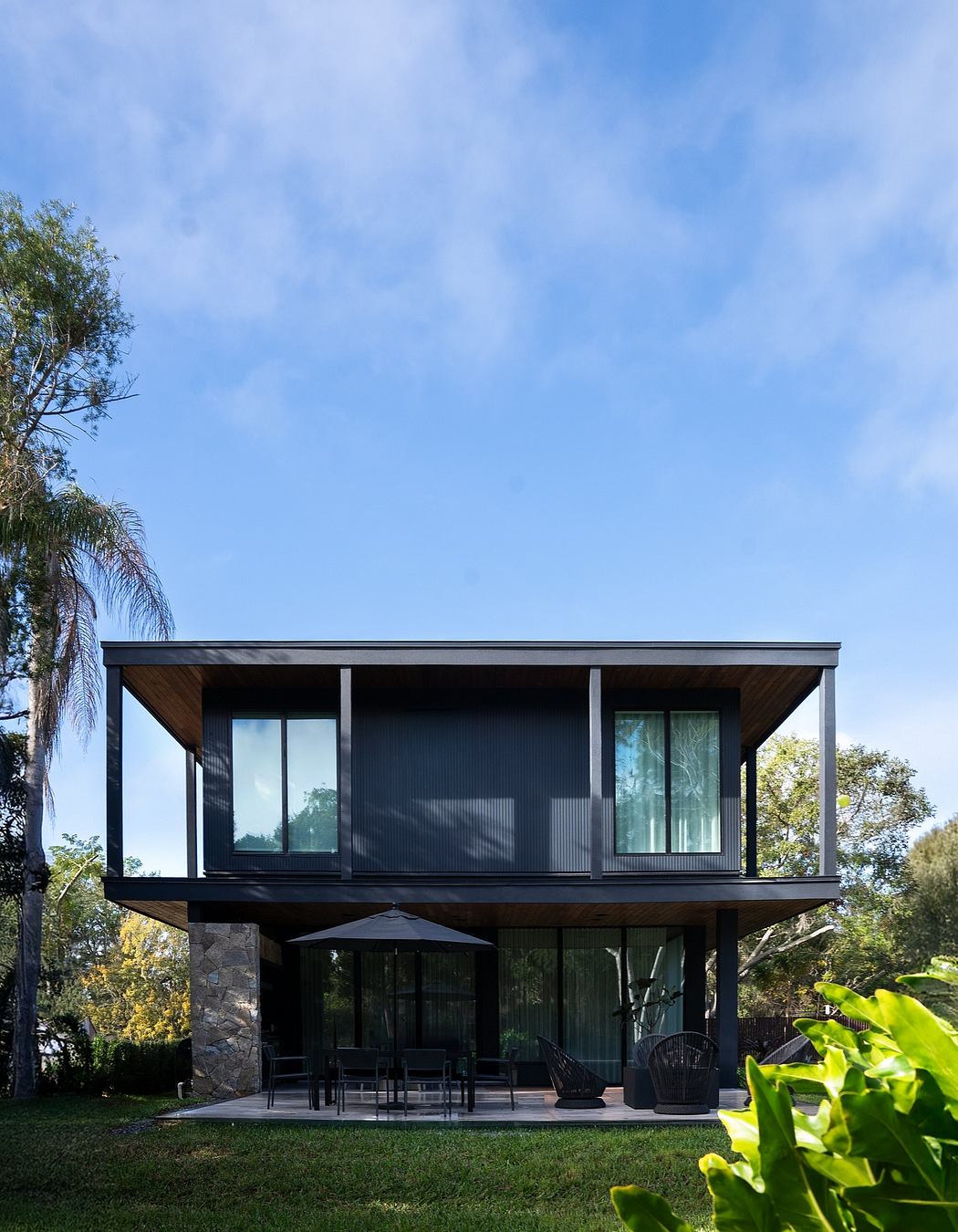 Contemporary outdoor patio with sleek black modern architecture, open floor plan.