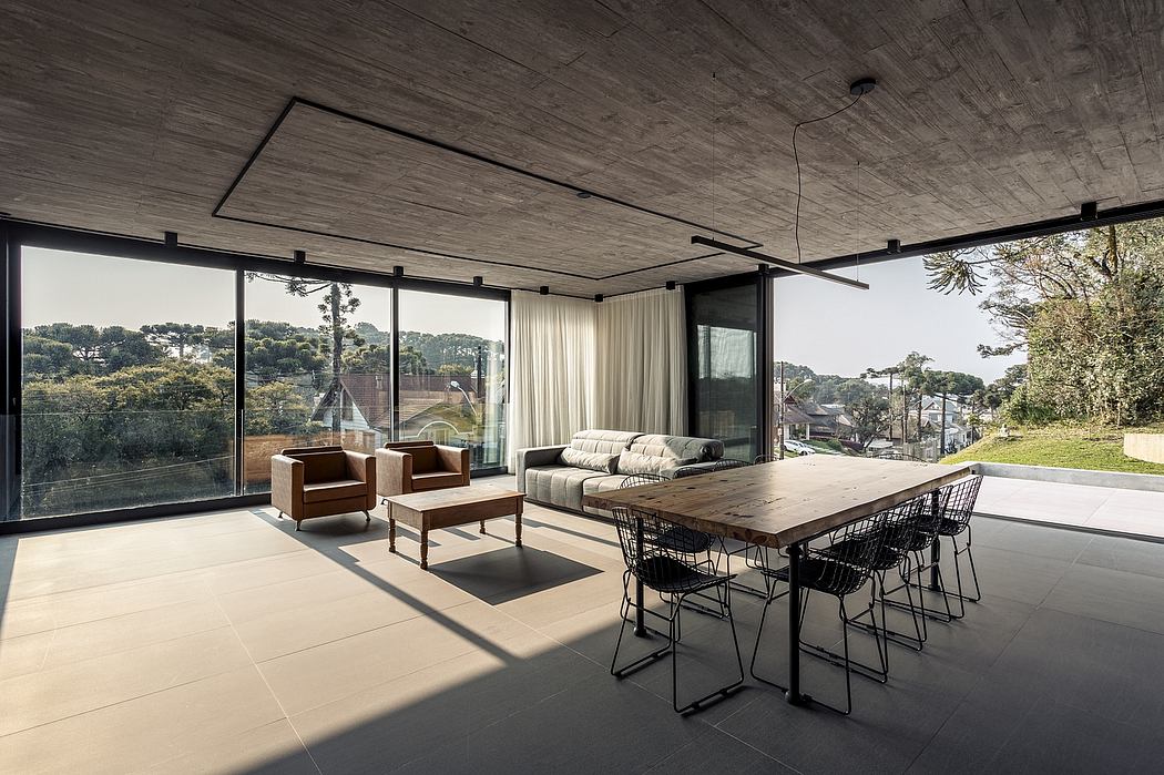 Spacious open-plan living area with expansive windows, wood-paneled ceiling, and modern furniture.