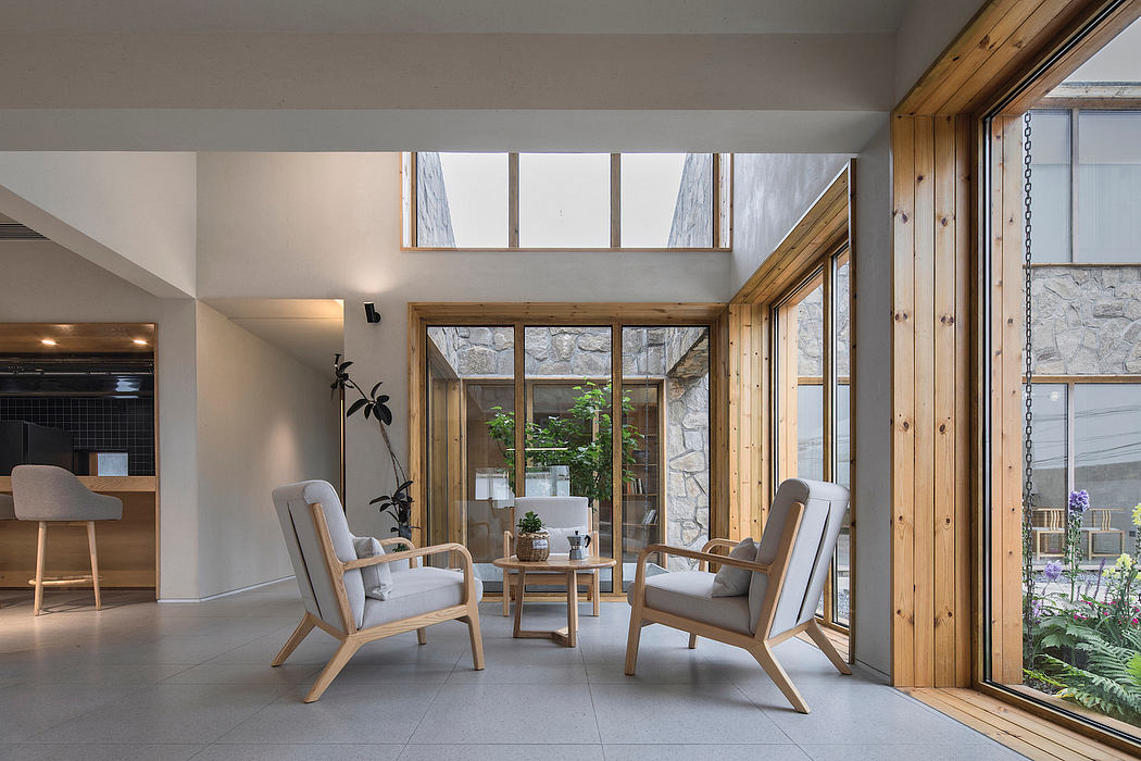 Spacious open-plan living area with wooden accents, large windows, and minimalist furniture.