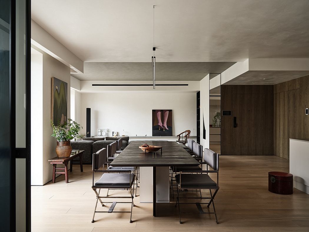 Spacious dining room with minimalist decor, wooden furniture, and industrial pendant light.