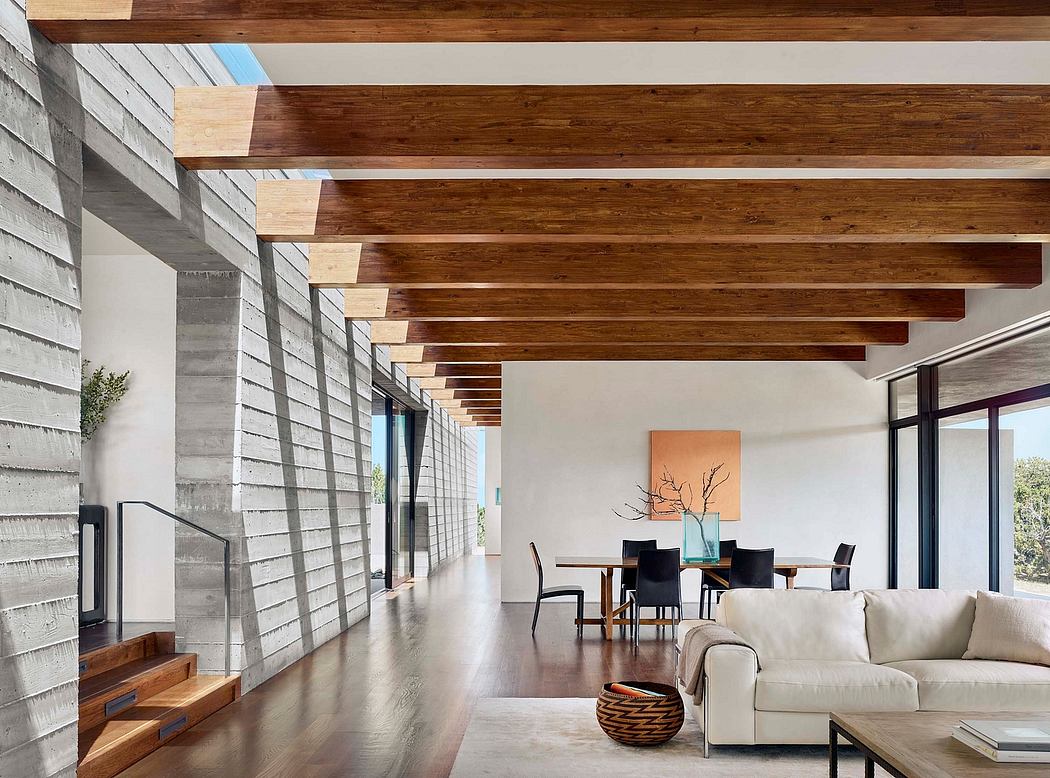 Spacious modern interior with wooden beams, concrete walls, and an open layout.