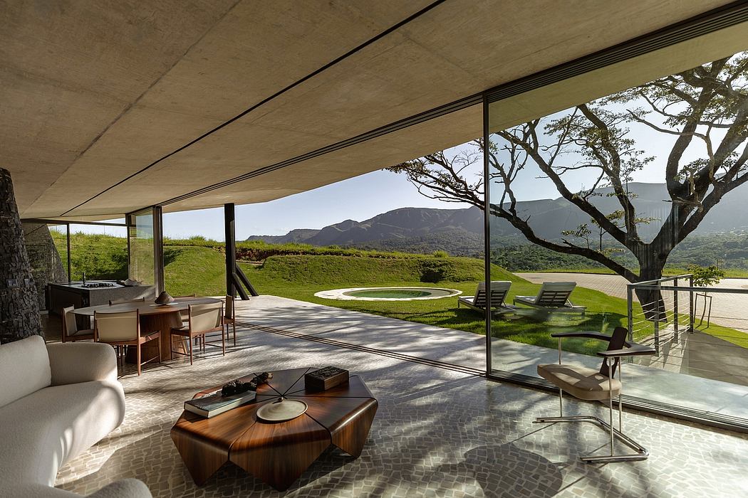Expansive glass walls frame a lush outdoor scene with a curved concrete overhang.
