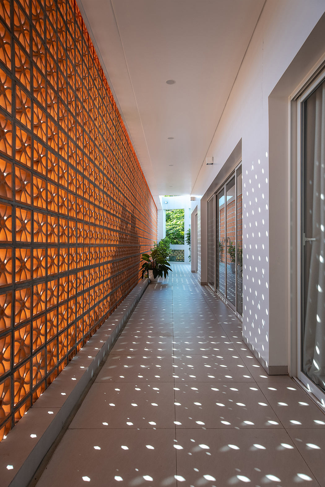 Vibrant orange lattice wall creates a striking architectural feature, casting intricate shadows across the floor.