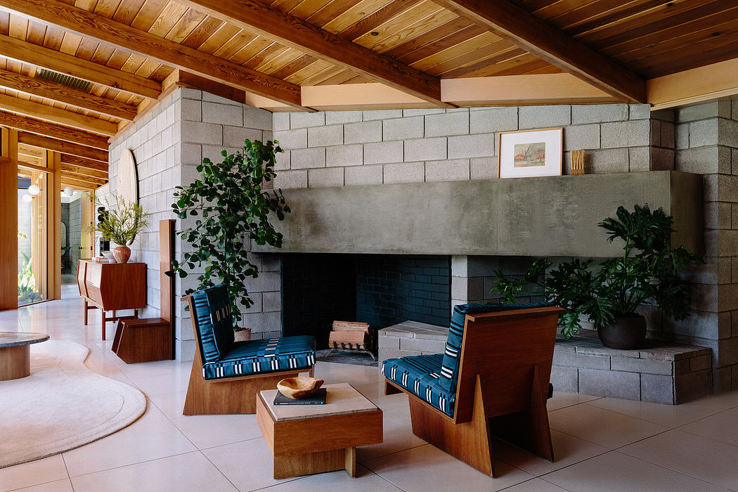 Warm, rustic interior with exposed beams, stone fireplace, and mid-century modern furniture.