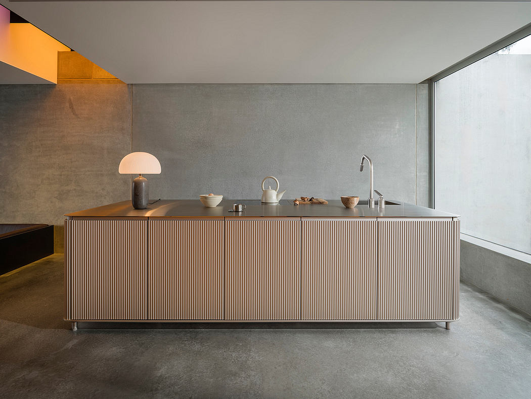 Modern, minimalist kitchen with ribbed wooden cabinets, sleek countertop, and warm lighting accents.